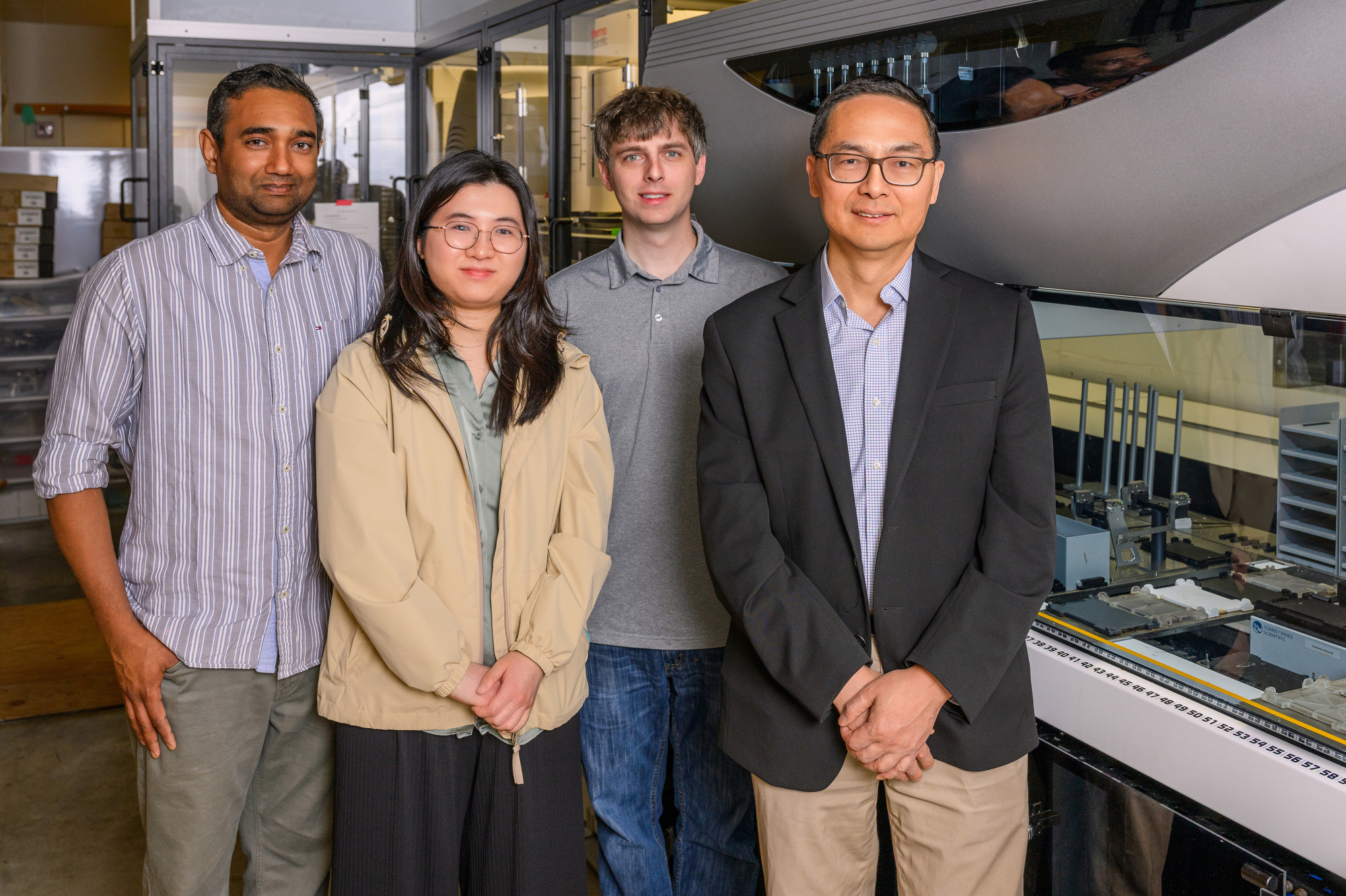 With AI to guide enzyme improvement and automated synthetic biology to rapidly make and test new variants, Illinois researchers developed a user-friendly system to drastically improve enzyme performance. Pictured, from left: Nilmani Singh, Jingxia Lu, Stephen Lane and Professor Huimin Zhao. Photo by Craig Pessman