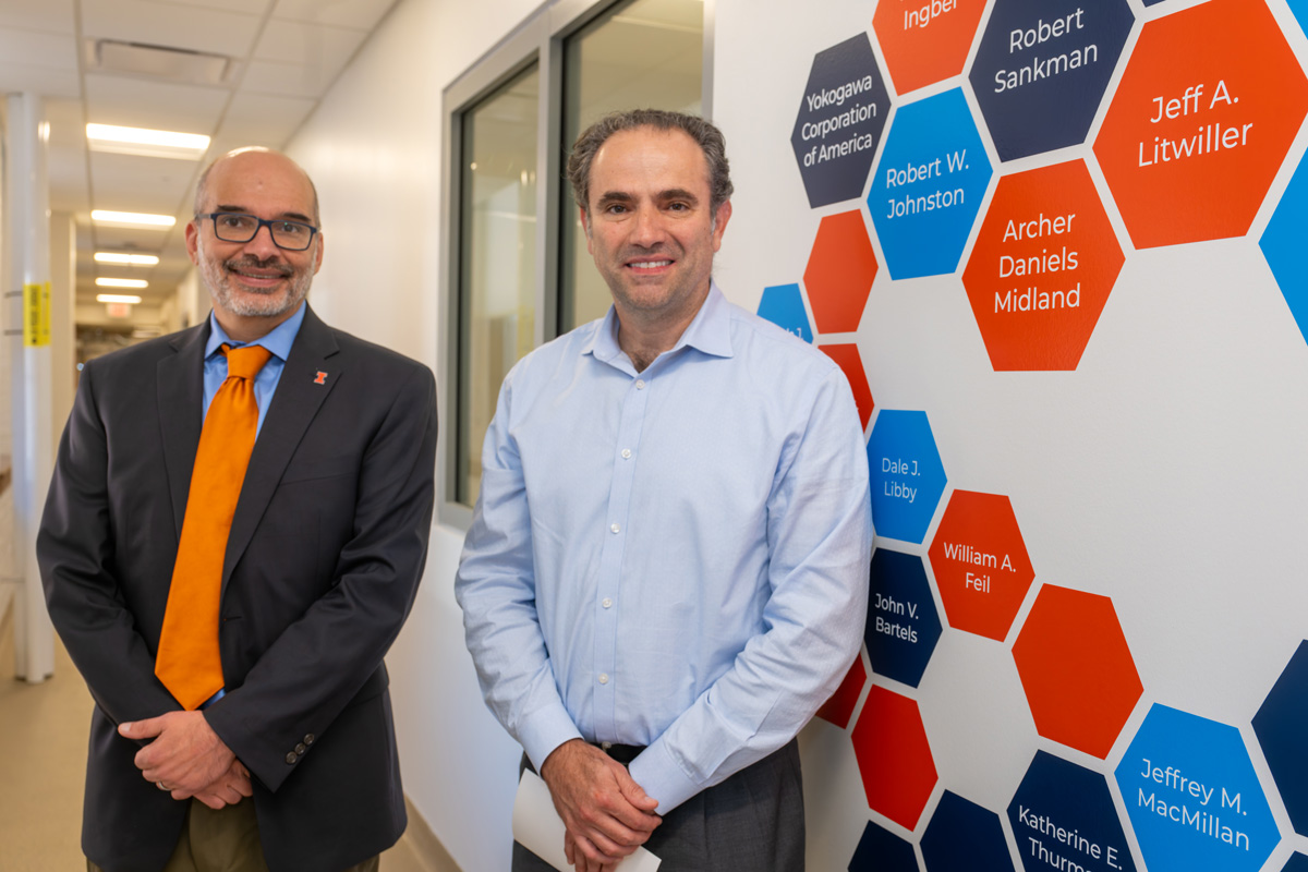 two men standing in front of the giving wall display