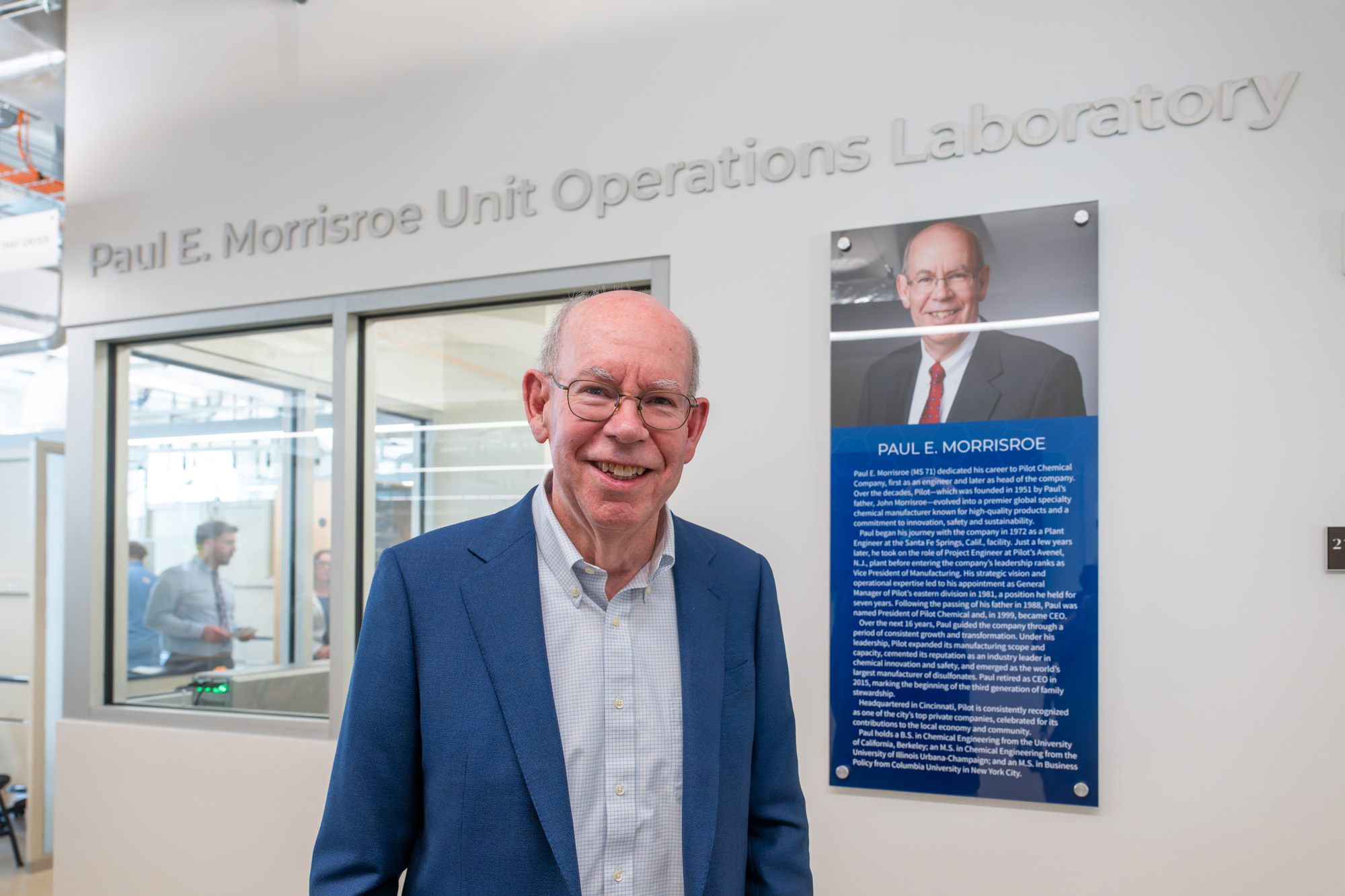 a man standing underneath a sign giving the name of the lab