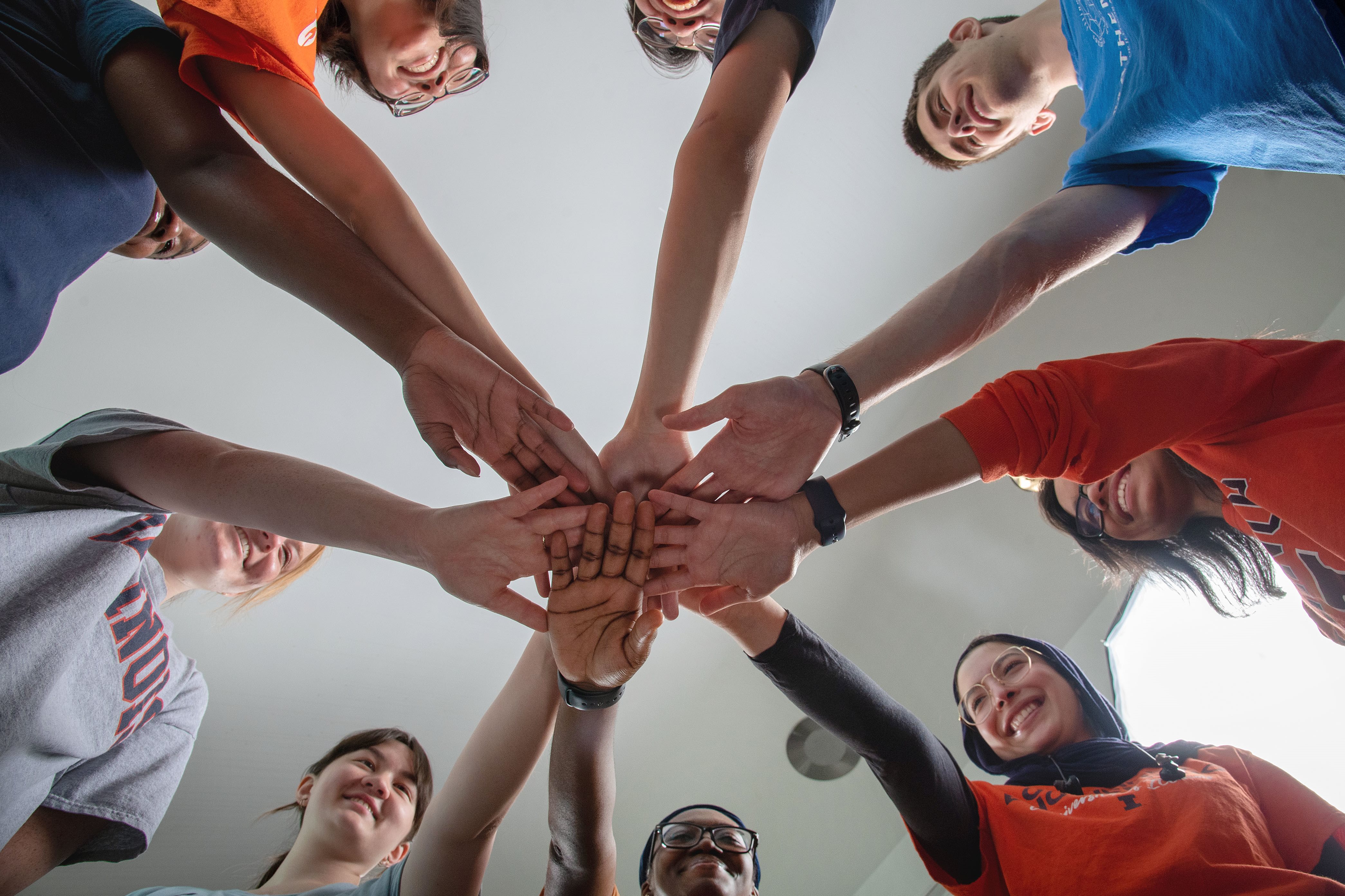 a group of students showing school spirit as they stand in a huddle with one arm reaching in