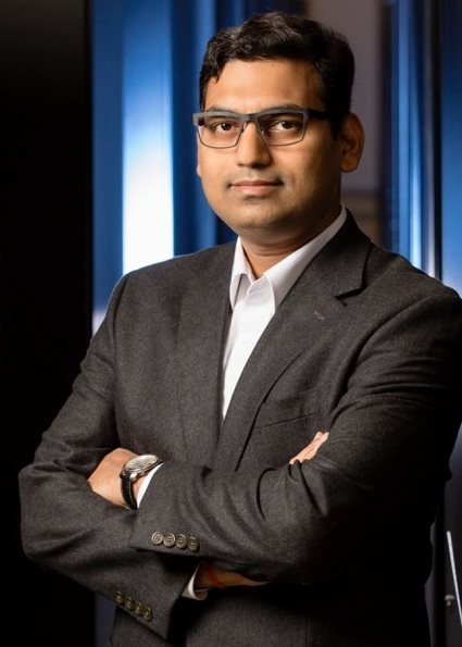 A man wearing a suit stands confidently for a photo.