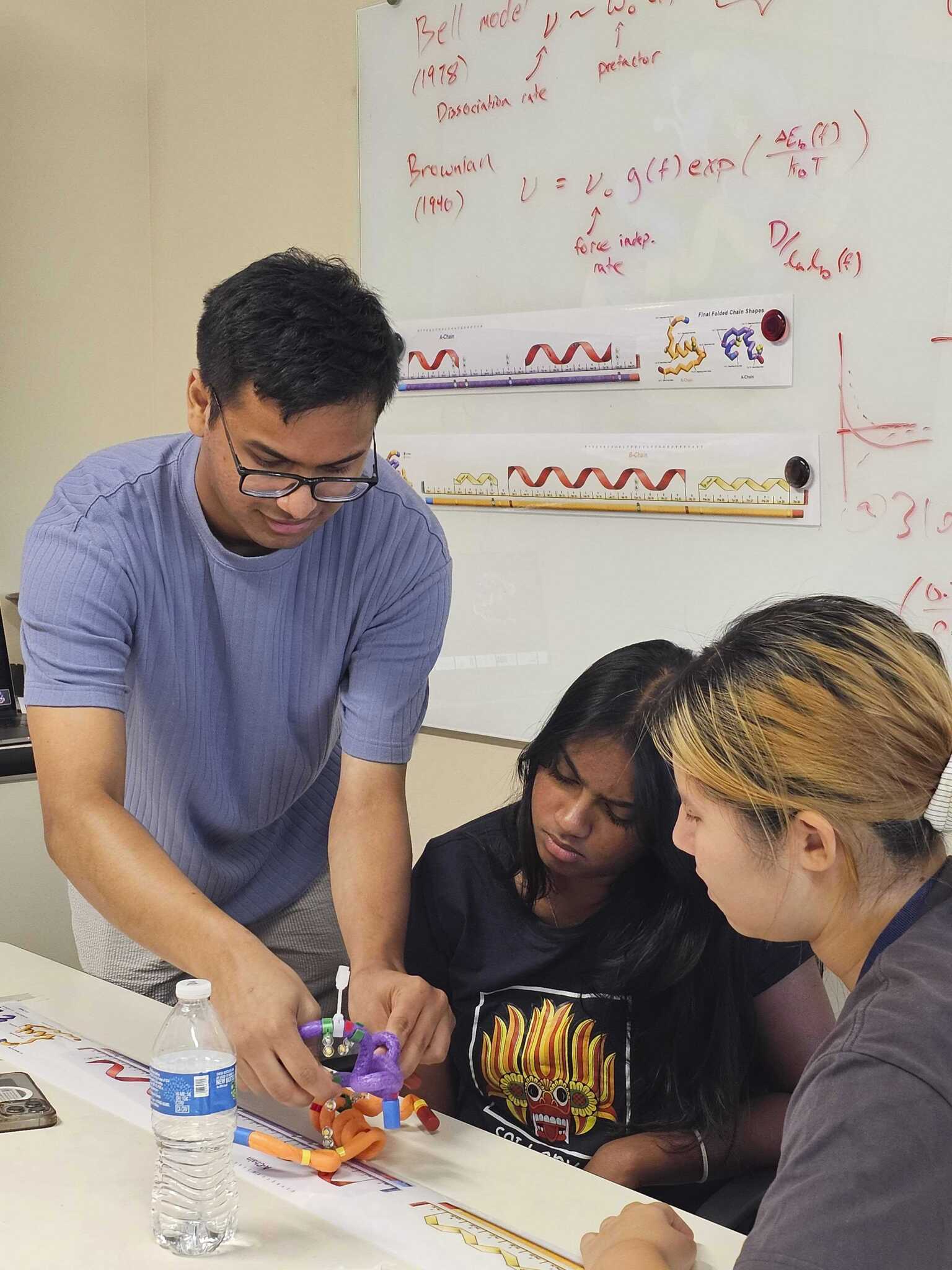 A group of students work together on a protein folding activity.