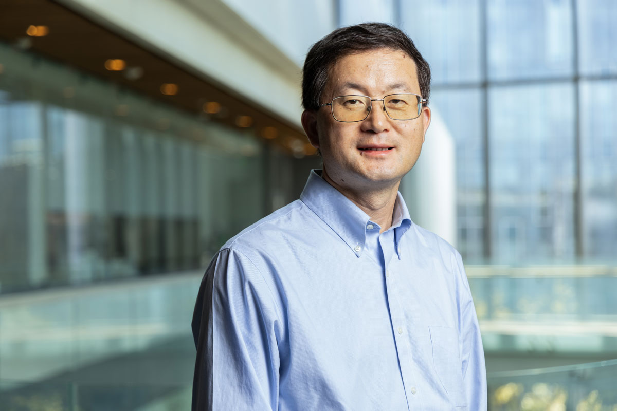 Liangfang Zhang standing in front of a blurred background