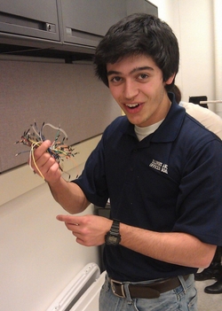 Chemical Engineering student Nick Connolly takes a break from working on his group's project, Lit Up Oil. The group has made a light-up, 3-D display of a simplified oil refinery to demonstrate the process by which crude oil is refined into usable products.