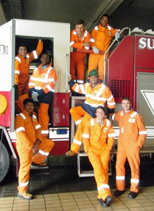 The BP winners wearing their Personal Protective Equipment standing by an onsite fire truck at the Sullom Voe Oil Terminal in Shetland, UK.