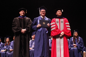 Department Head Paul J. A. Kenis and Lecturer Troy Vogel pose with a new graduate during the May 18 ceremony.