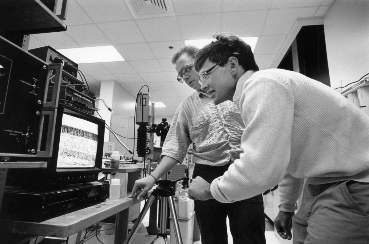 Charles Zukoski (foreground) and graduate student Patrick Maloney examine structures developed in electrorheological fluids in 1989.