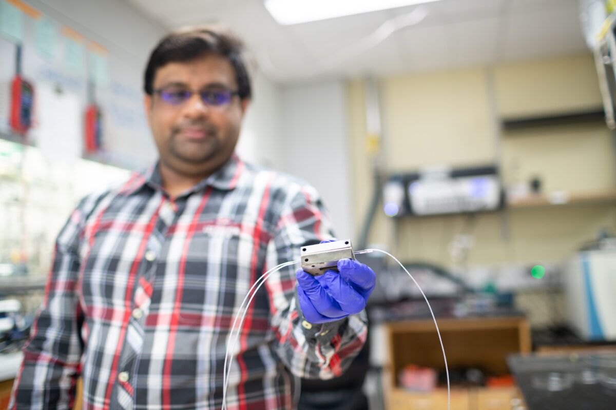 Chemical and biomolecular engineering graduate student Saket Bhargava holds a flow electrolysis cell.