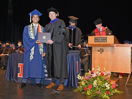 Paul J. A. Kenis presents diploma covers to the graduates.&amp;amp;amp;amp;nbsp;