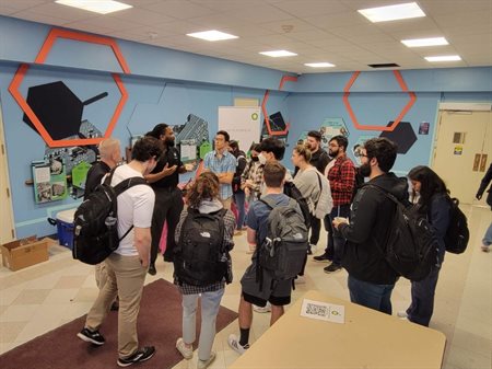 Students gather around Tunde Dokun at information session